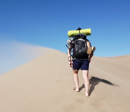 Man Barefoot in Sand 8 Benefits of Camping